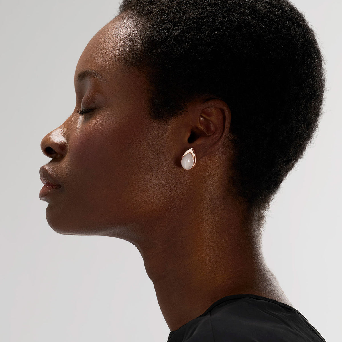 A convertible brooch-earring jewel worn as earring featuring an ingenious mechanism that allows the post to extend or retract, offering multiple ways to wear the piece: on its own, as an earring or a brooch, or attached to another brooch. Crafted in 18k gold, this piece is set with a white moonstone, evoking the shimmering reflection of light on the surface of water.