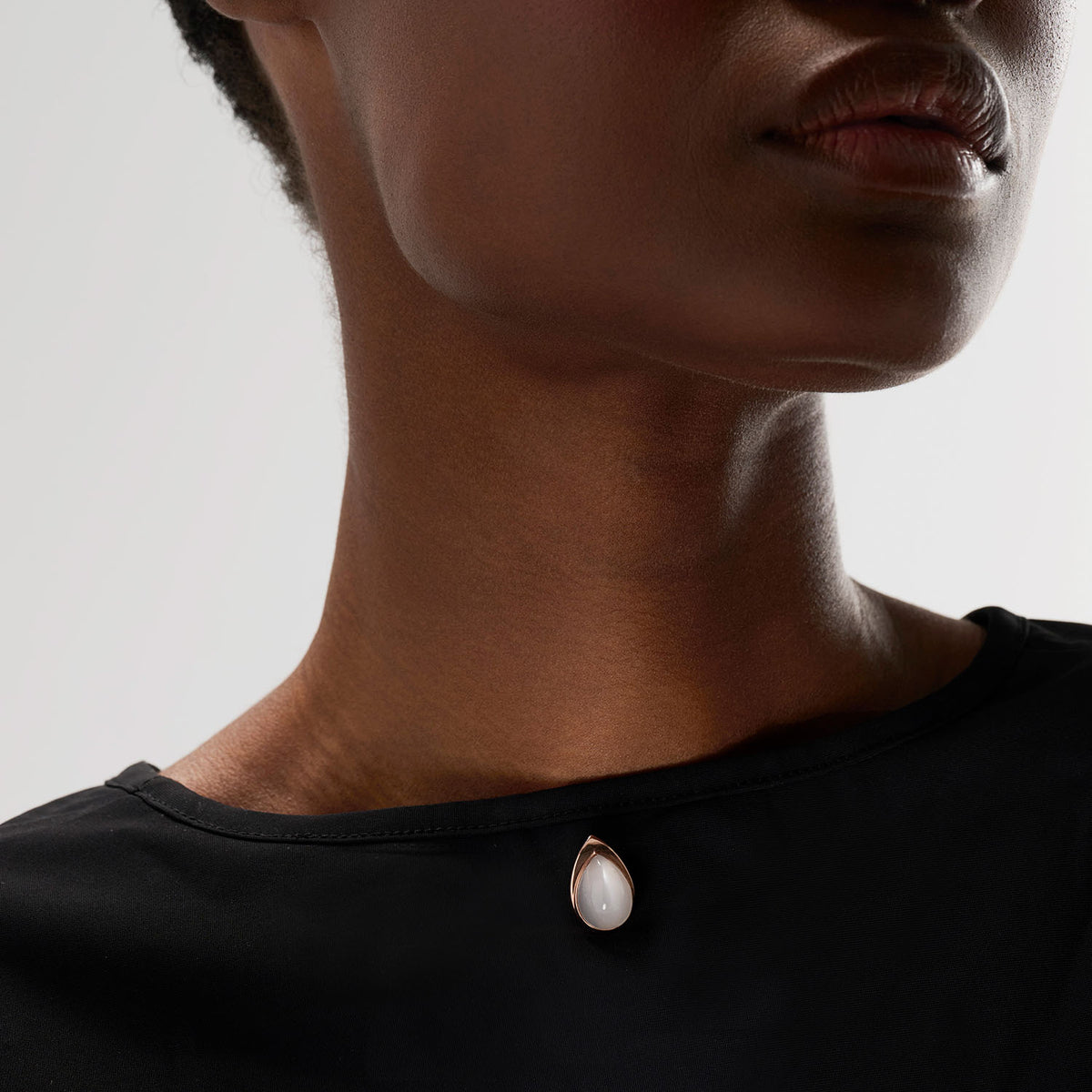 A convertible brooch-earring jewel worn as brooch featuring an ingenious mechanism that allows the post to extend or retract, offering multiple ways to wear the piece: on its own, as an earring or a brooch, or attached to another brooch. Crafted in 18k gold, this piece is set with a white moonstone, evoking the shimmering reflection of light on the surface of water.
