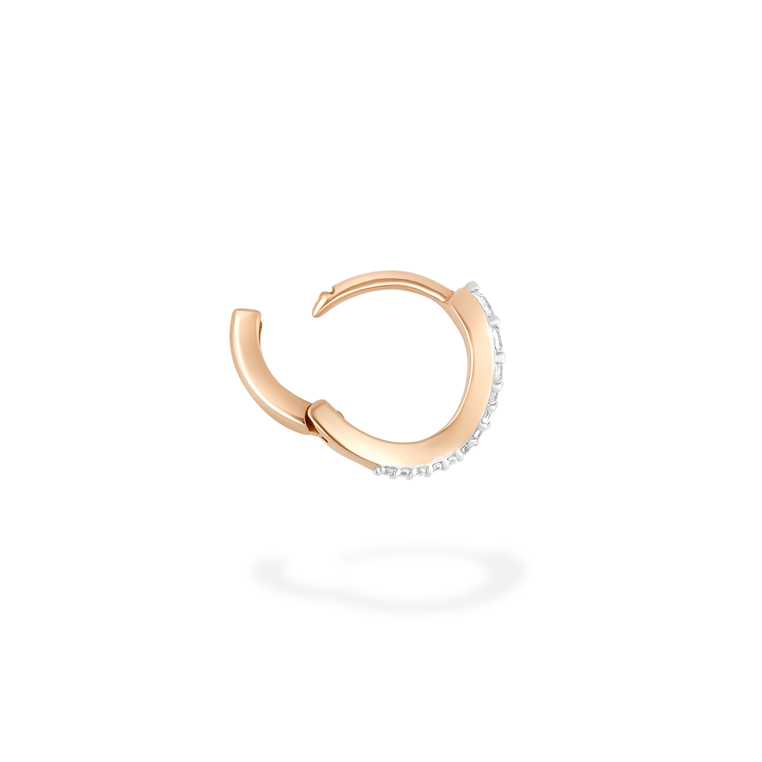 A mini hoop earring presented here in profile. This piece is crafted in 18k rose gold and set with natural diamonds. This jewel and its undulations are inspired by the Caustics, the luminous phemonem of light meeting water.